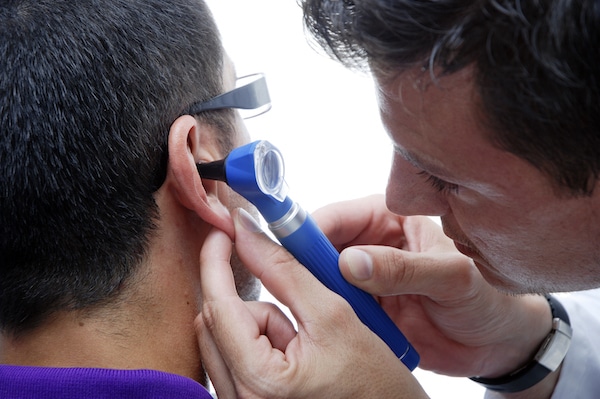 Doctor looking in his patient's ear