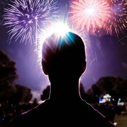 a man looking out at fireworks