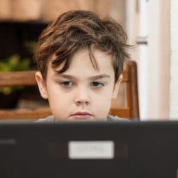Young boy doing school work on a laptop at home