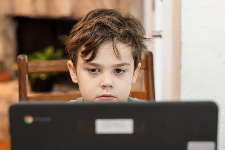 Young boy doing school work on a laptop at home