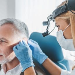 Man having his ears examined by a medical professional.